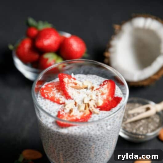 Keto Coconut Chia Pudding with fresh strawberries and coconut chips in a glass
