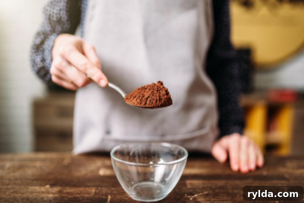 A spoonful of rich unsweetened cocoa powder, essential for deep chocolate flavor in brownies.