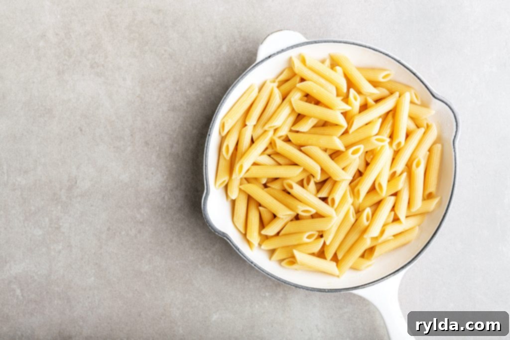 Close-up of perfectly cooked penne rigate pasta, highlighting its characteristic ridges that are ideal for clinging to rich and creamy sauces, ensuring maximum flavor in every bite.