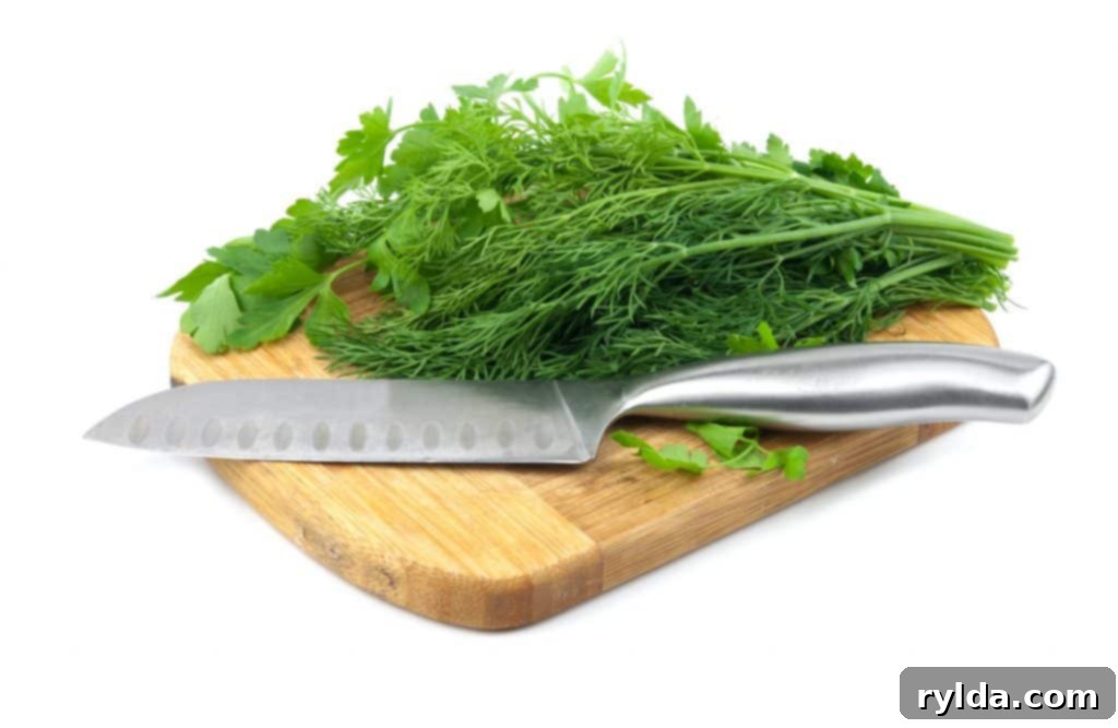 Golden Herb Garlic Baked Salmon 4 Fresh dill and parsley on a wooden cutting board.