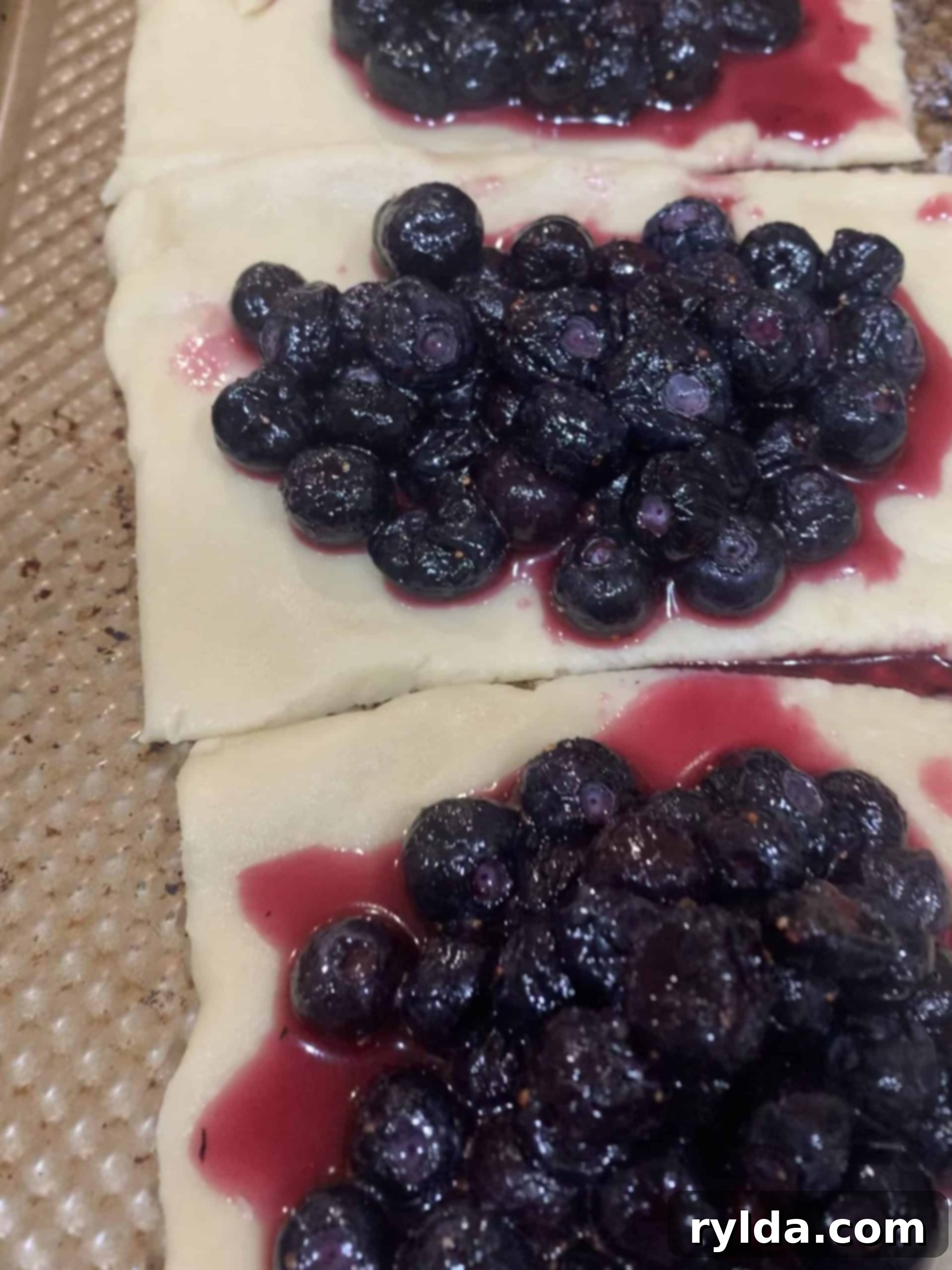 Freshly filled blueberry hand pies ready for the oven, showcasing the fruit filling.