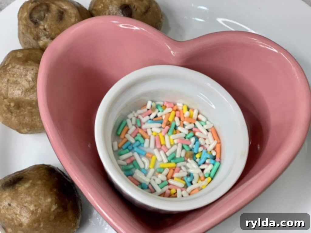 Close-up of chocolate chip cookie dough balls pressed with colorful pastel sprinkles