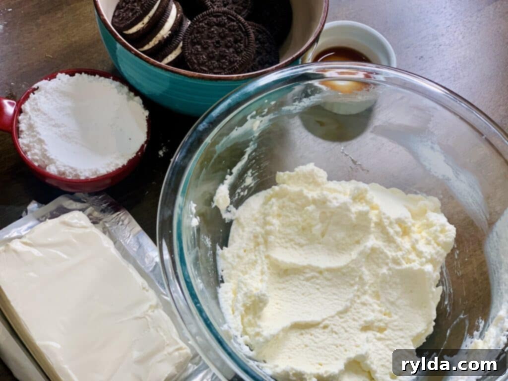 All ingredients laid out for making the creamy Oreo Dip, including heavy cream, cream cheese, powdered sugar, vanilla extract, and Oreo cookies.