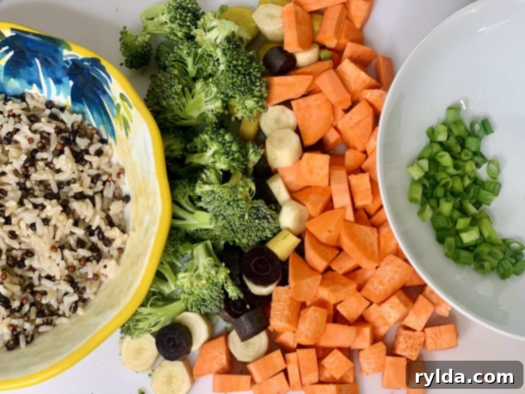 Assortment of fresh ingredients for a grain bowl, including vegetables and grains.