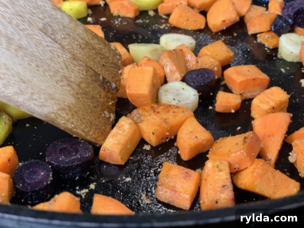Broccoli florets cooking in a skillet with other vegetables.