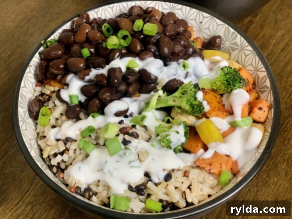 A close-up of a grain bowl, emphasizing the fresh green onion garnish.