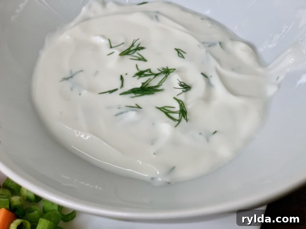Lemon Dill Greek Yogurt Dressing in a small bowl, garnished with fresh dill.