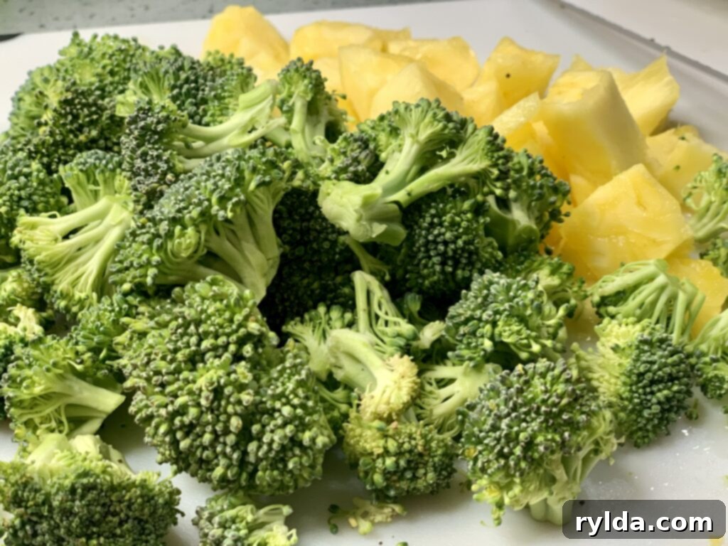 A beautifully arranged serving of Pineapple Chicken and Broccoli, highlighting the saucy chicken, bright broccoli, and caramelized pineapple pieces.