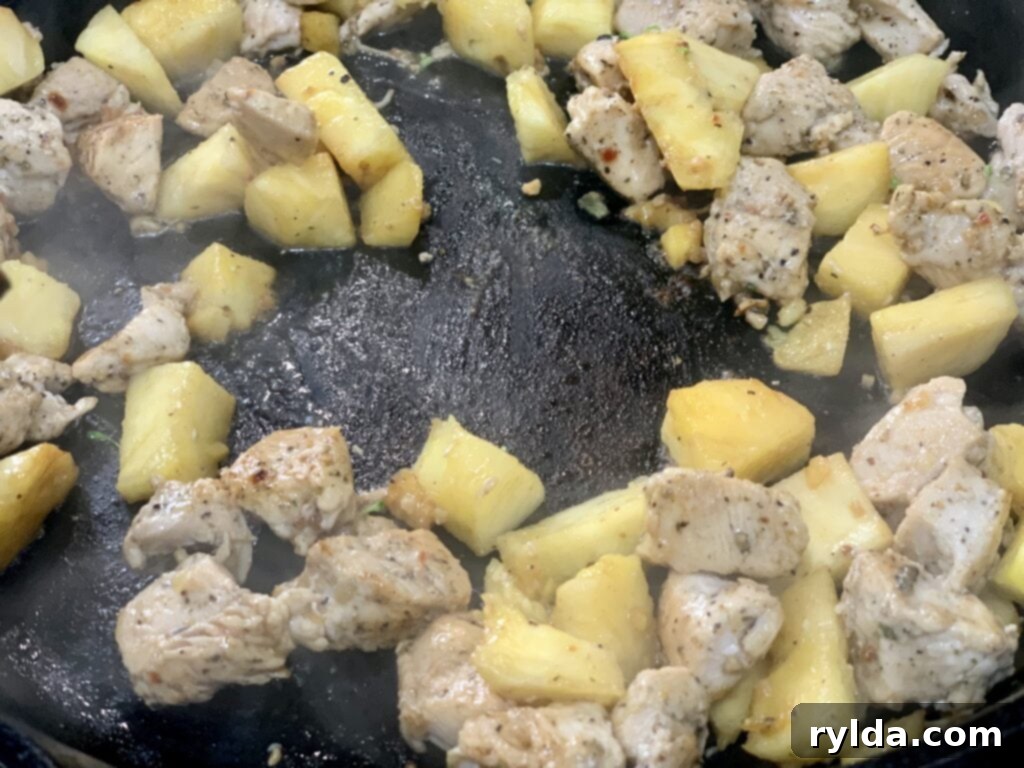 Fresh ingredients laid out for preparation: whole pineapple, raw chicken breast, and vibrant broccoli florets, emphasizing freshness.