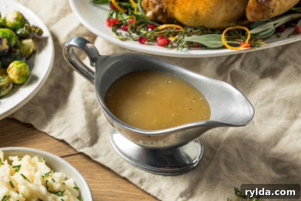 Delicious homemade roast chicken gravy being poured from a gravy boat into a serving dish, ready to accompany a succulent roast chicken. This rich, dark gravy is a perfect example of how pan drippings can elevate a simple meal.