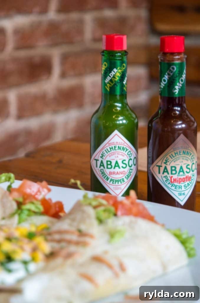 Close-up shot of a bottle of Tabasco hot sauce, with a blurred background suggesting a kitchen setting.